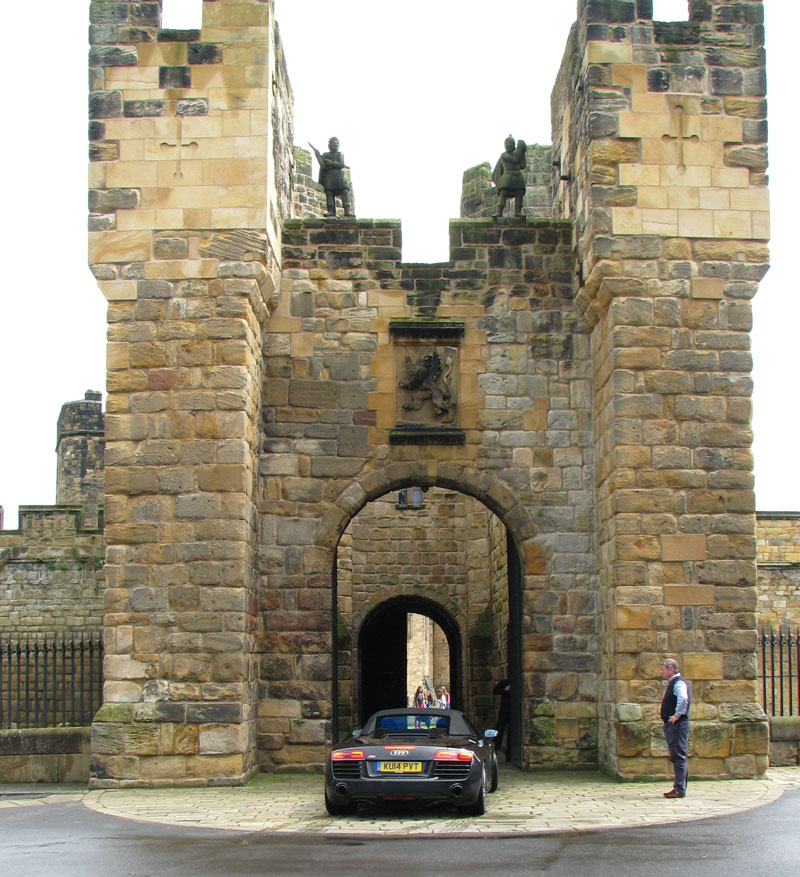 Audi R8 Spyder entering Alnwick Castle through the main gates of the Barbican