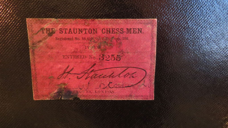 Red label affixed to inside of mahogany brass bound Jaques chess set box