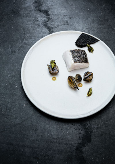 Slow baked hake with burned onion puree and pickled onions by chef Petter Nilsson