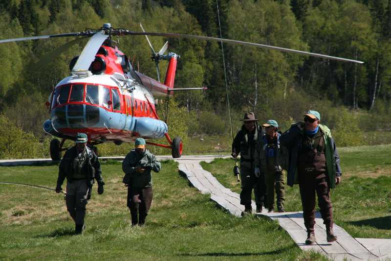Returning to camp after a days fishing with helicopter in background